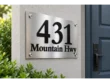 Left angled view of a stainless steel 431 Mountain Hwy plaque showing raised black numbers and dimensional street lettering.
