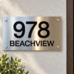 Horizontal Stainless Steel Address Sign - Horizontal brushed stainless steel address sign with black 978 numbers and BEACHVIEW lettering beside a wooden door.