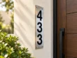 Left-angle view of a slim brushed stainless steel plaque with black 433 numbers stacked vertically.
