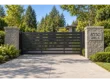 Modern driveway gate between stone pillars, with a brushed stainless steel 8550 ANSELL PL address plaque on the right.