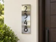 Vertical Brushed Stainless Steel Number Plaque - Vertical brushed stainless steel plaque displaying black 2548 numbers beside a wooden entrance door.