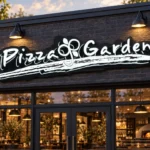 custom illuminated restaurant signs - Pizza Garden sign with white illuminated script and a shaped black backing above a dark brick restaurant entrance.
