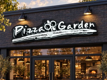 custom illuminated restaurant signs - Pizza Garden sign with white illuminated script and a shaped black backing above a dark brick restaurant entrance.