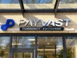 Payvast storefront sign with silver-coloured dimensional letters, a blue logo, and a dark Currency Exchange panel on cream brick.
