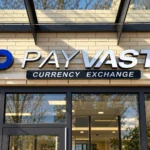 Payvast storefront sign with silver-coloured dimensional letters, a blue logo, and a dark Currency Exchange panel on cream brick.