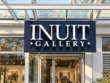 White Inuit Gallery channel letters mounted on a navy backing plate above a glass entrance.