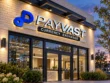 Wider view of the Payvast sign with a blue logo and dimensional lettering above a glass storefront entrance at dusk.