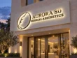 Angled view of the Aurora 80 custom backlit lightbox sign showing dimensional gold-tone lettering and halo illumination.