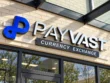 Angled close-up of Payvast’s silver-coloured letter faces, dark dimensional sides, blue logo, and Currency Exchange panel.