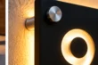 Close-up detail of stainless steel standoff and warm backlighting on matte black cut-through illuminated address sign.