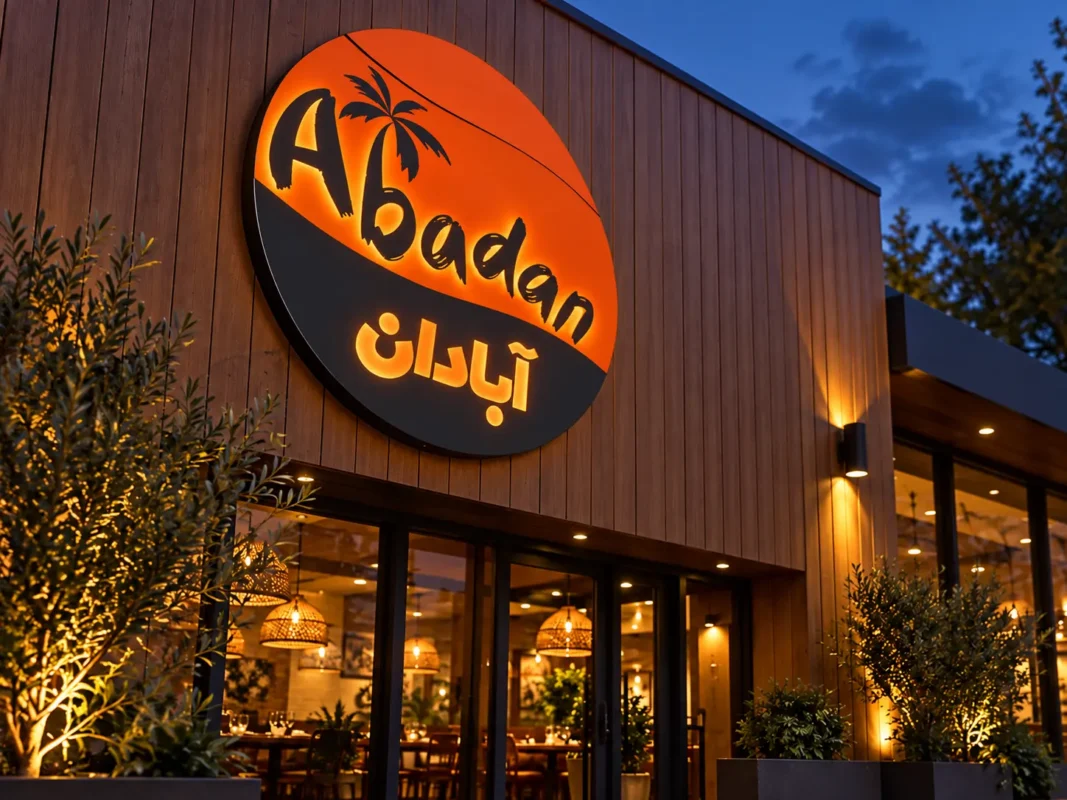Angled view of the Abadan custom round lightbox sign showing the circular cabinet depth and orange and charcoal branding.