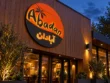 Angled view of the Abadan custom round lightbox sign showing the circular cabinet depth and orange and charcoal branding.