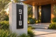 Custom vertical cut-through house number sign 918 beside a contemporary entrance