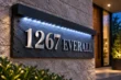 Angled close-up of the textured natural slate sign with raised silver-tone address lettering and top-mounted LED lighting.