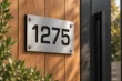 Cut-out brushed aluminum address sign 1275 with black backing beside a cedar entrance