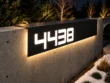 Close-up of the bent aluminium top and illuminated 4438 face wrapping over a concrete wall edge.