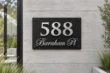 Brushed silver address sign 588 with Barnham Pl mounted on a contemporary concrete wall